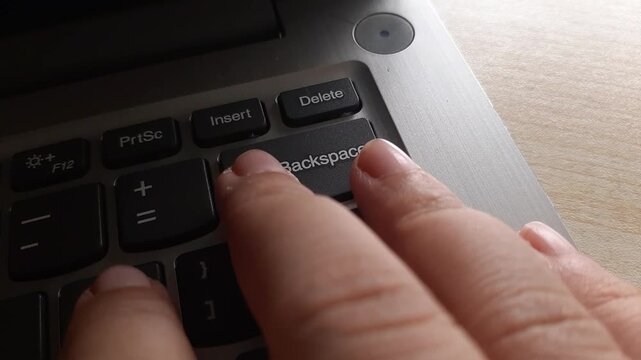 hand pressing the backspace key over and over