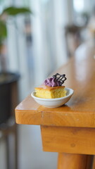 a cupcake on a white plate on a wooden table, breakfast menu in the morning, with natural lighting in the morning