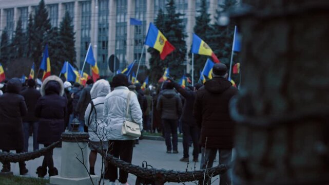 Chisinau, Republic of Moldova - December 06, 2020: Moldovan citizens with national flags gathered for a peaceful protest in front of the Government building