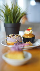 a cupcake on a white plate on a wooden table, breakfast menu in the morning, with natural lighting in the morning