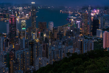 Viewed From Victoria Peak Over Hong Kong Night Skyline With Illuminated Skyscrapers And Dense...