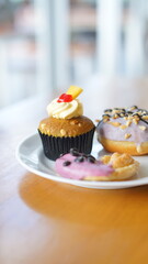 a cupcake on a white plate on a wooden table, breakfast menu in the morning, with natural lighting in the morning
