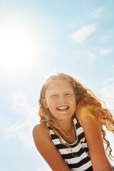 Happy girl, portrait and blue sky with sunshine below for holiday, weekend or outdoor freedom. Low...