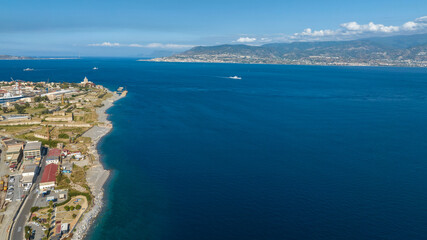 Fototapeta premium Aerial panorama of the Strait of Messina. It is a narrow strait between the eastern tip of Sicily and the western tip of Calabria, in Southern Italy. It connects the Tyrrhenian Sea with the Ionian Sea
