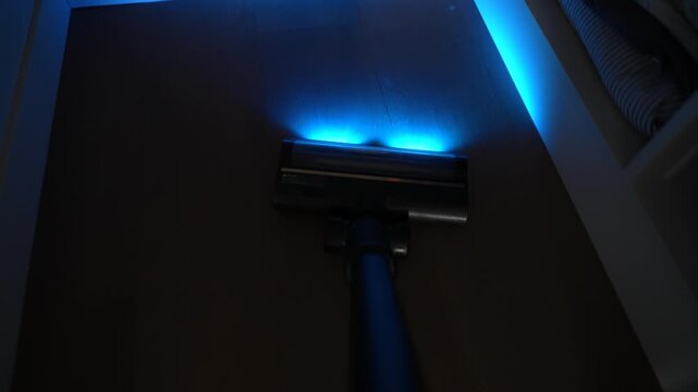 House cleaning video: vacuuming hardwood floors with a UV flashlight. Top view.