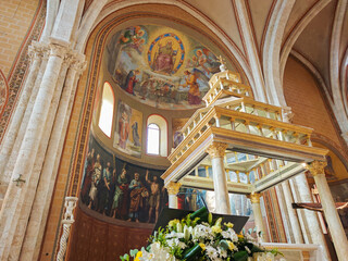 Interior view of the historic Anagni Cathedral in Lazio, Italy, featuring a ornate golden baldacchino over the main altar and large medieval apse frescoes