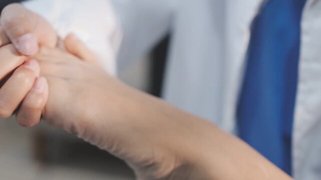 A close-up of a physical therapist or podiatrist examining and treating a patient's foot and ankle.
