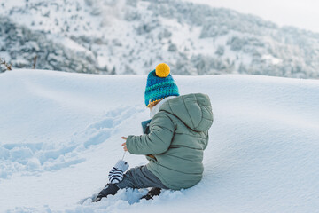 Cute Baby Boy Playing in Snow Wearing Warm Winter Clothes