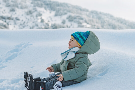 Cute Baby Boy Playing in Snow Wearing Warm Winter Clothes