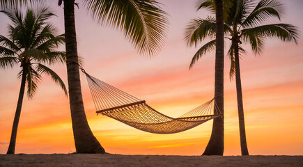Silhouette of hammock between palm trees on tropical beach at sunset with beautiful orange sky for summer vacation and travel concept