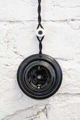 Black Socket in retro style. The electrical socket in vintage style on a white brick wall.