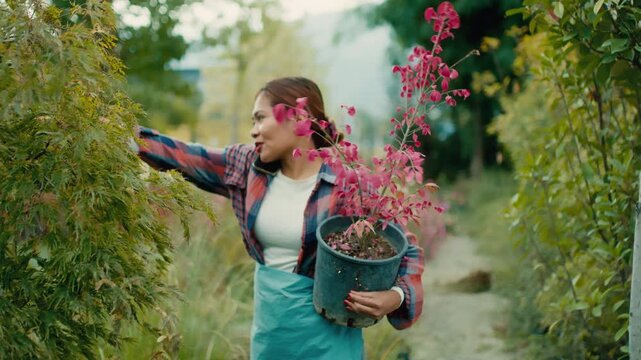 Woman Holding Potted Plant in Garden Center