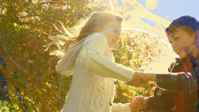 Two children holding hands and turning in a park