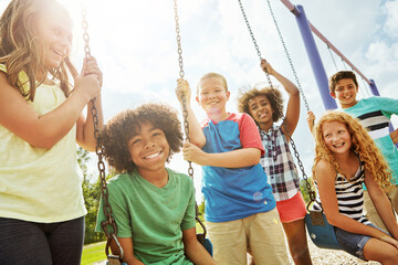 Below, kids and smile with friends at playground for playtime, activity and bonding together. Portrait, children and playing on swing for fun, group reunion and weekend break for holiday trip at park