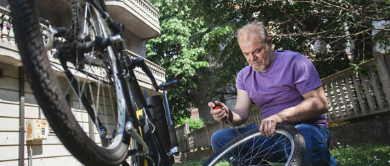 Middle Aged Man Repairing Bicycle at Home