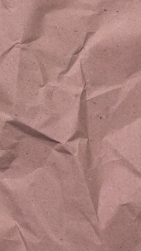 A vertical orientation of crumpled recycled kraft paper. This textured background is perfect for mobile-first content, Instagram stories, and sustainable marketing aesthetics with a grunge feel.