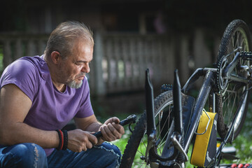 Middle Aged Man Repairing Bicycle at Home