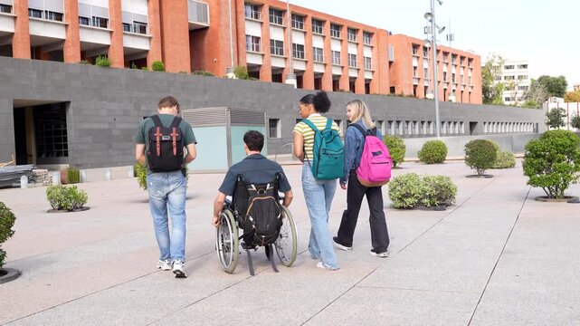 Disabled student in wheelchair with friends at university campus