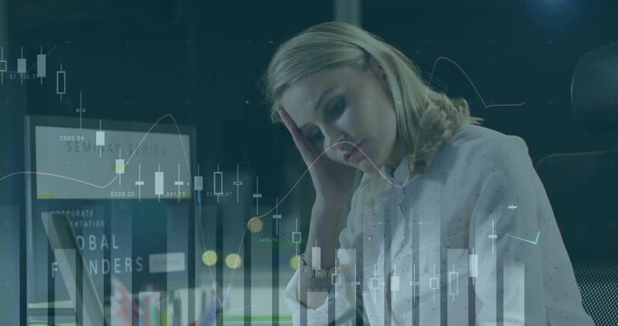 Overlaying financial data charts, businesswoman looking stressed at her workspace