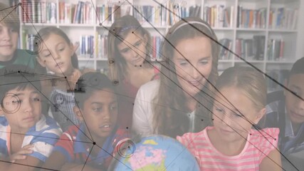 Educator placing hand on globe rotating it while children pointing then smiling before bookshelves - Powered by Adobe