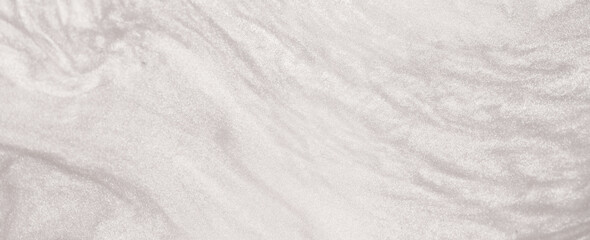 Obraz premium Shimmering silver abstract background. Liquid glitter paint texture waves and swirls. Beautiful shiny white glitter texture. Metallic silver paint close-up as a holiday background.