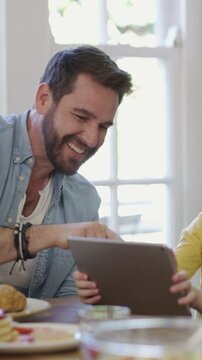 Breakfast, tablet and high five with father and son in home for support, elearning success and love. Goal, online education and studying with dad and kid in family house for achievement and praise