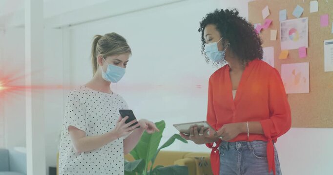 Animation of data processing over businesswomen wearing face masks