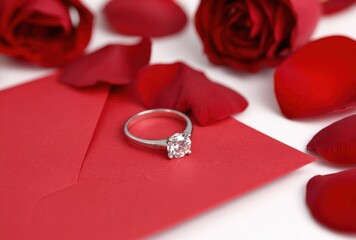 A diamond ring is on top of a red card