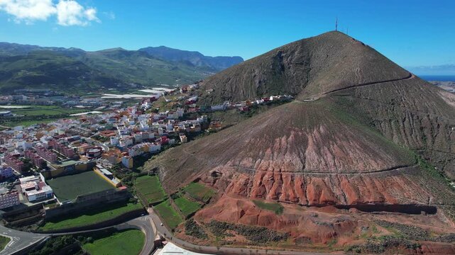Drone flight over the city of Galdar and its iconic mountain in the Canary Islands on a sunny day