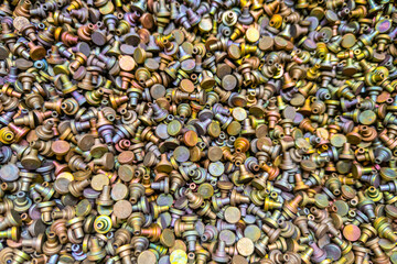 Pile of iridescent Cadmium chromate plated parts , full-frame closeup view