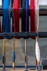 Colorful yarn spools on a traditional weaving loom