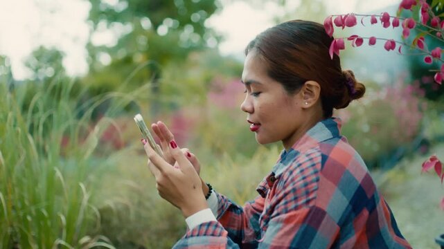 Young Woman Using Smart phone in Garden