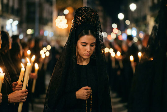 Procesi&oacute;n nocturna en primer plano, mujer vestida de mantilla negra con guantes de encaje sosteniendo un rosario