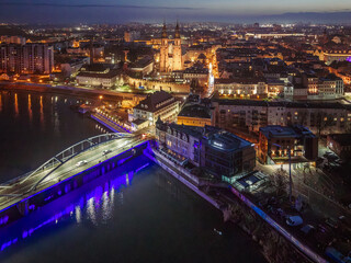 Malownicza nocna panorama Opola z lotu ptaka, przedstawiająca rozświetlony Most Piastowski, iluminację kanału Młynówka oraz wieże katedry na tle miejskich świateł. © Henryk Niestrój