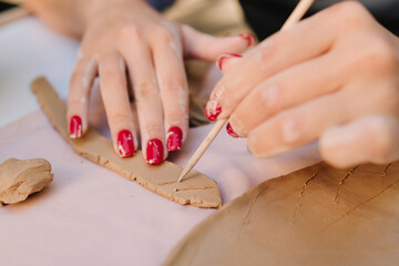 Clay Decoration and Detailing. Clay decoration highlights artistic detail as pottery makers carve precise lines into handmade ceramics. Close-up of clay artistry shows decorative carving techniques.
