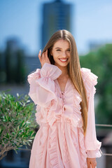 Smiling Young Woman In Pink Ruffled Dress, Long Hair, Touching Hair, Natural Makeup, Blurred