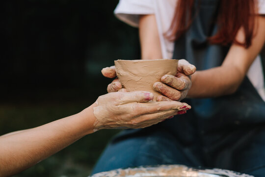 Handmade clay bowl is held after removal from the wheel. Ceramic pot reflects artistry, patience, and cultural tradition. Finished clay pot in hands.