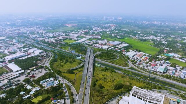 4K Aerial View Of Heavy traffic flowing through the major intersection of Vo Van Kiet Boulevard and National Route 1A in Ho Chi Minh City, Vietnam. Visible mix of cars, motorbikes, cargo trucks