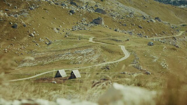 Exploring a remote estate in Montenegro along a winding road surrounded by hills and valleys in durmitor nationa park