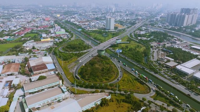 4K Aerial View Of Heavy traffic flowing through the major intersection of Vo Van Kiet Boulevard and National Route 1A in Ho Chi Minh City, Vietnam. Visible mix of cars, motorbikes, cargo trucks