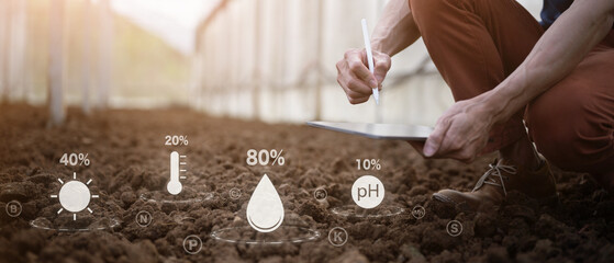 Farmer checks soil quality by hand using digital data icons to analyze nutrients pH moisture with tablet