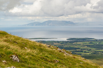 Fototapeta premium a wide panoramic view from the peak of a mountain over the Atlantic sea to the wild irish coast with a beautiful mountain range at sligo, ireland