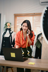 Fashion blogger concept, Young Asian women selling clothes and talking her smartphone with customer