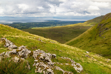 a wide panoramic view from the peak of a mountain over the Atlantic sea to the wild irish coast with a beautiful mountain range at sligo, ireland