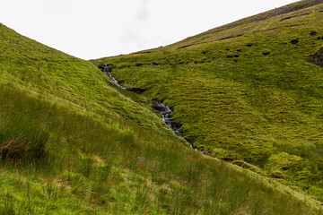 a small mountain waterfall at the mountain range next to the Ben Bulben in the area of gortnaleck sligo, ireland