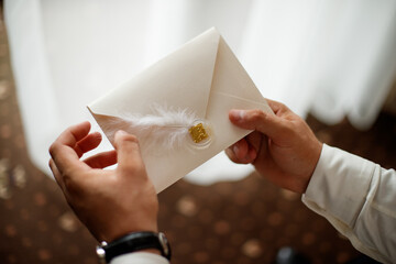 A close-up of two hands holding a romantic envelope containing a love letter, sealed with a red wax seal. Perfect for Valentine's Day, wedding invitations, romance, and love.