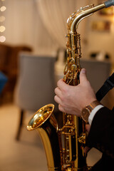 Medium closeup of unrecognizable Black jazz musician playing saxophone on stage in local bar