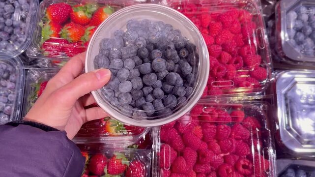 buying fruits and  berries ( raspberries, blueberries, strawberries, gooseberries)at the market