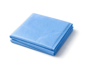 Photorealistic 3D macro product-shot of an unbranded sterile surgical drape folded into a neat square, visible nonwoven fabric microtexture and subtle creases, clean sealed edges