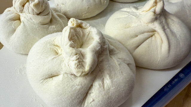 Plump, uncooked khinkali dance like chubby snowflakes, celebrating Georgian cuisines rustic charm and the winter rebirth of Surva